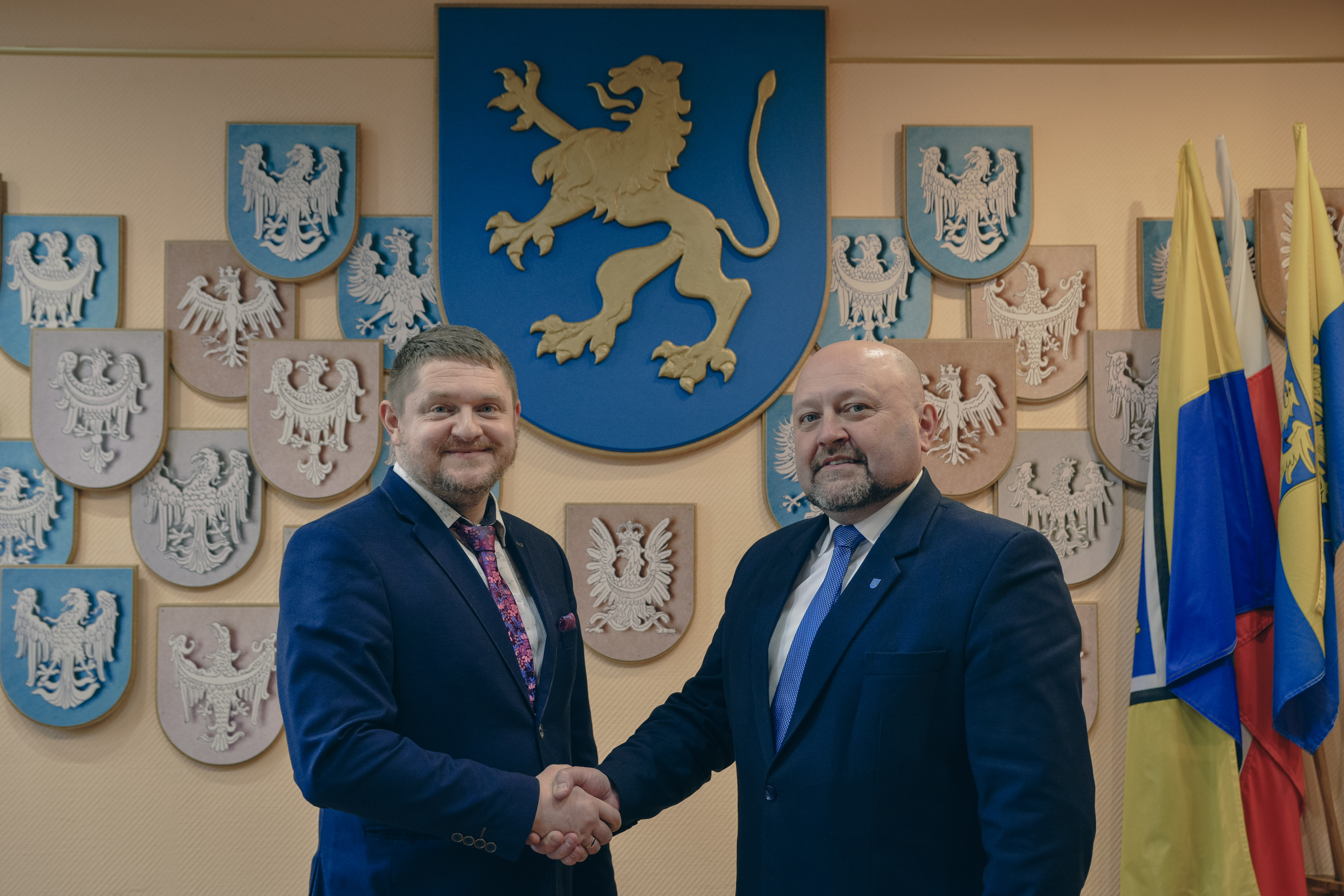 Nowy Wicew&oacute;jt Gminy Marklowice podaje rękę obecnemu W&oacute;jtowi, w&nbsp;tle na&nbsp;ścianie herb Gminy Marklowice