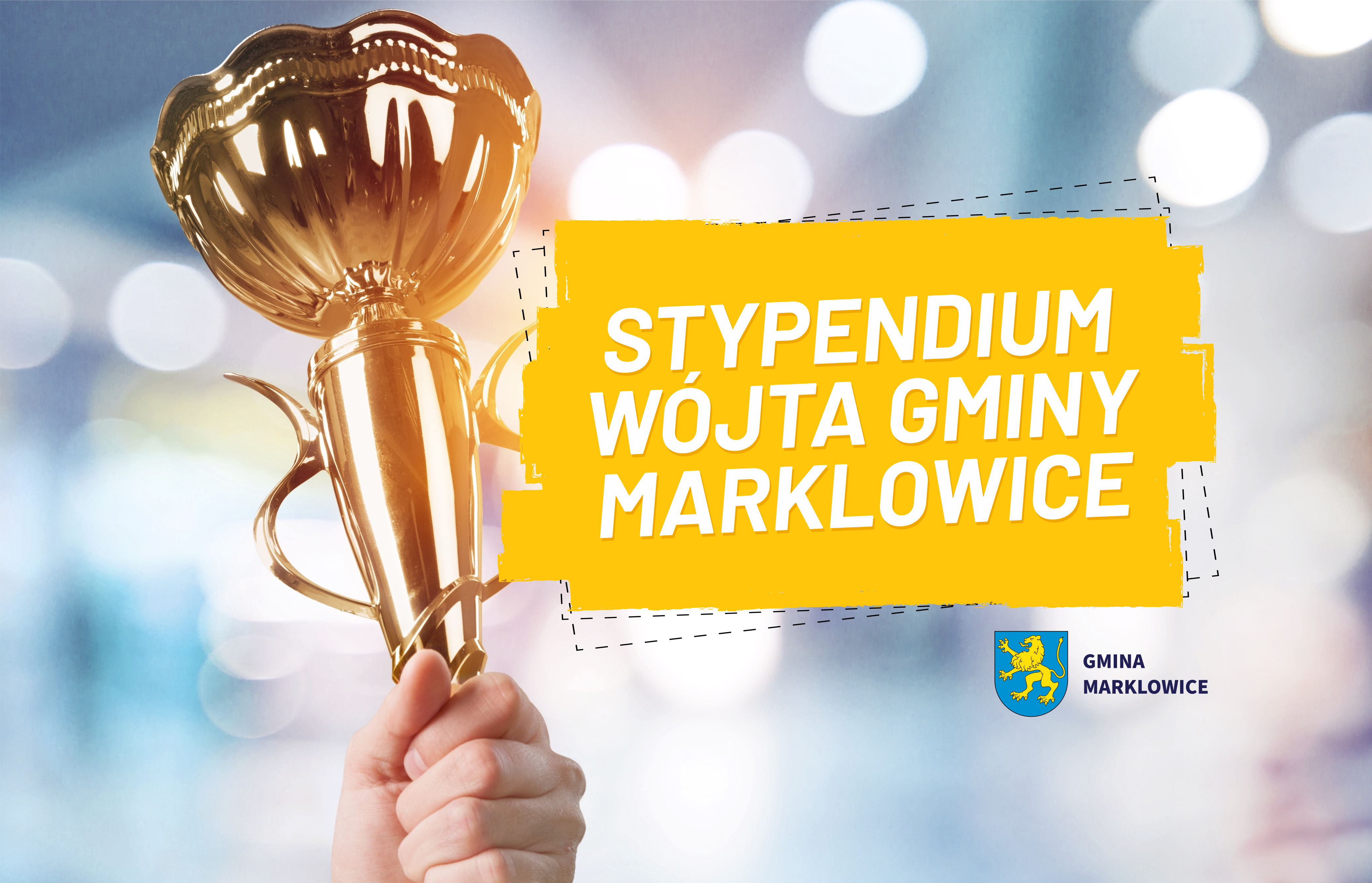 Czyjaś dłoń trzyma złoty puchar, obok napis na&nbsp;ż&oacute;łtym tle "STYPENDIA W&Oacute;JTA GMINY MARKLOWICE"