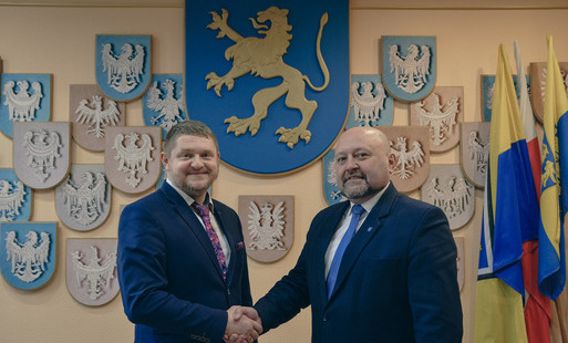 Nowy Wicewójt Gminy Marklowice podaje rękę obecnemu Wójtowi, w tle na ścianie herb Gminy Marklowice