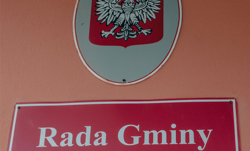 Tablica na ścianie budynku z napisem "Rada Gminy MArklowice" a nad nią tablica z godłem Rzeczpospolitej Polskiej