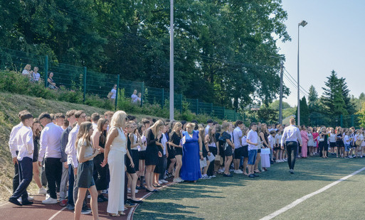 Duża grupa uczniów zebranych na boisku szkolnym